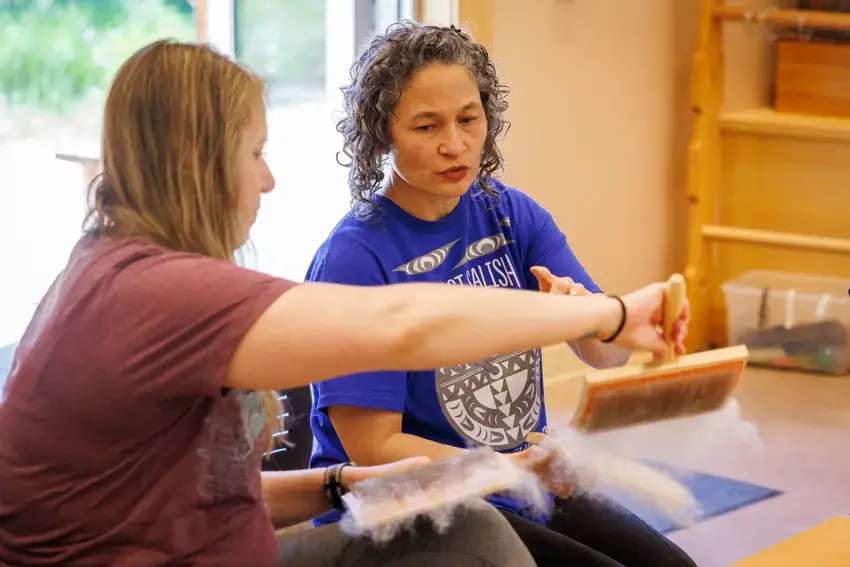 Student and faculty member, Susan Pavel, process wool as part of the weaving course being taught at the Indigenous Arts Campus.