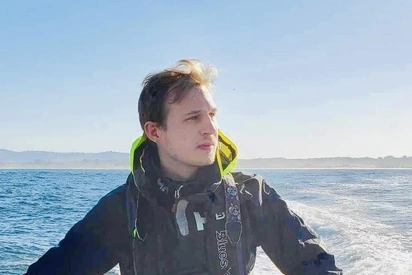 Kevin Lester sitting on the side of a boat out on the water