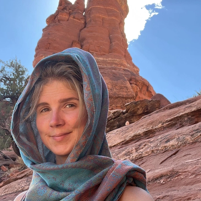 Brookelle with a scarf wrapped around their face out hiking