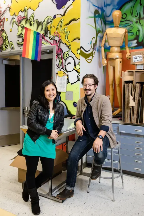 a student teacher and their mentor teacher and evergreen alum stand together in arts classroom facing the camera smiling