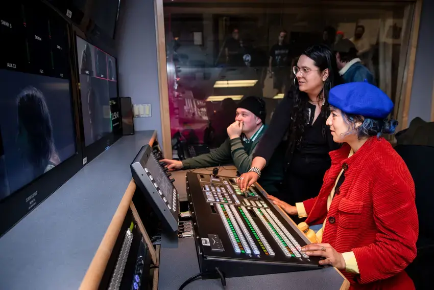 two students over a sound and light board in CCAM