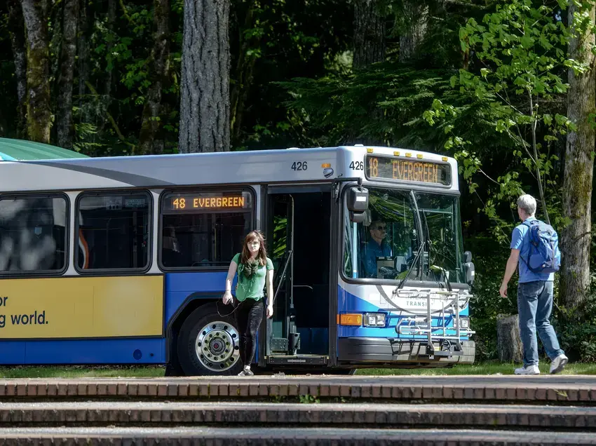 student disembarks a metro bus in the evergreen bus loop