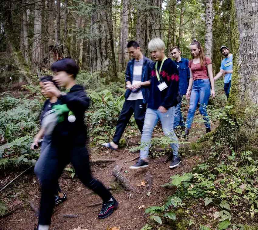 Group of students walk through the woods on their way to the beach