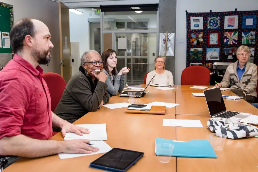 a group of faculty and staff around a table in the wa center