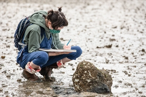 Student writing in the field